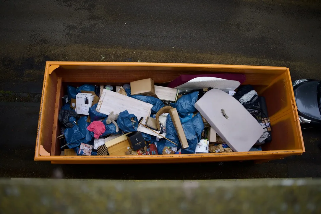 Container mit Hausrat nach einer Haushaltsauflösung – Möbelteile, Kartons und verpackter Restmüll, von oben fotografiert