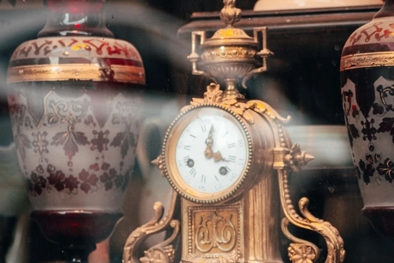 Antike Standuhr und Vasen – Nachlassankauf in Schwäbisch Gmünd Antike Standuhr aus vergoldeter Bronze zwischen bemalten Vasen in einer Vitrine